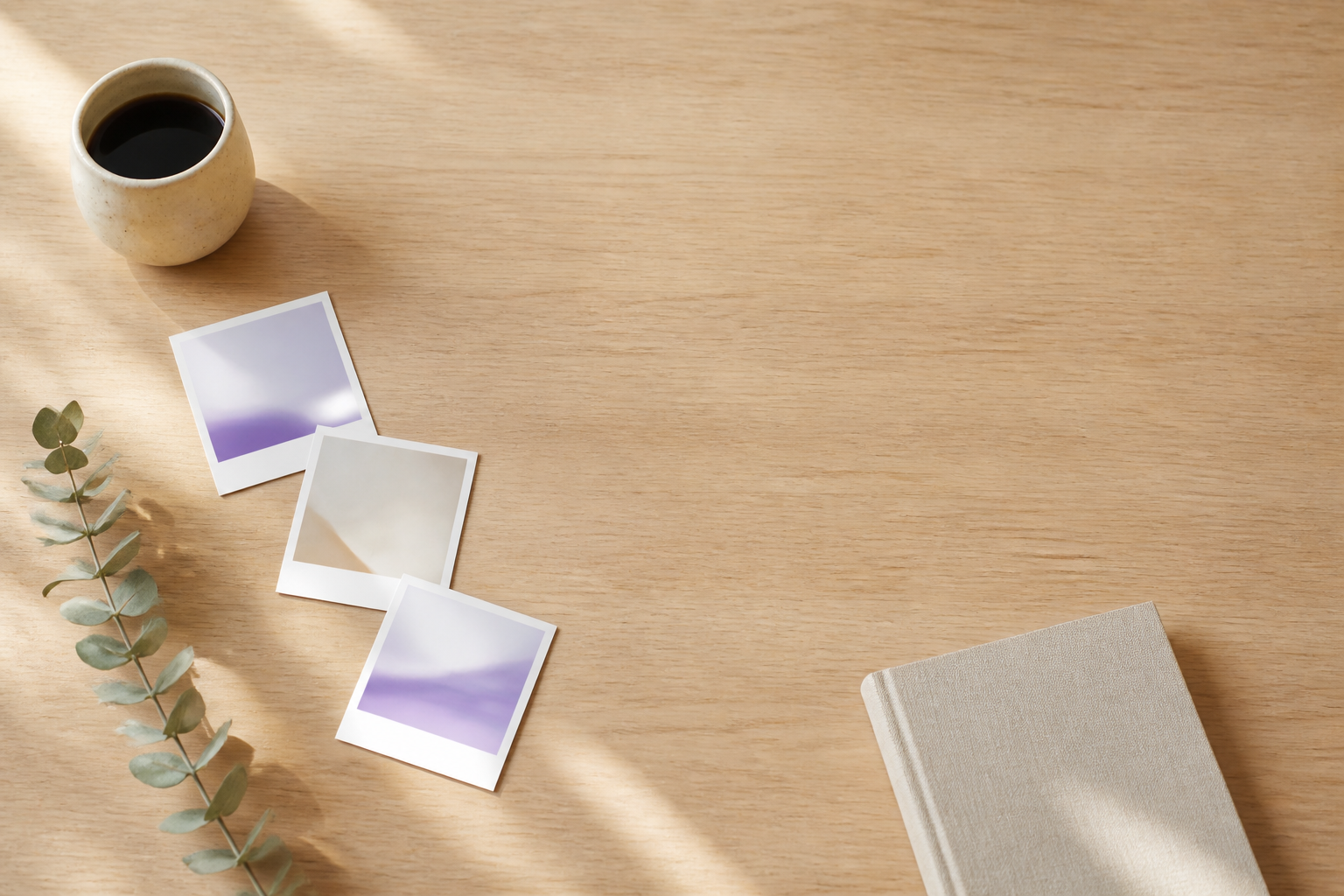 Sunlit oak table with abstract photo prints